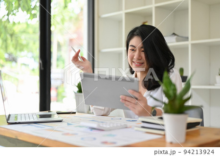 Asian businesswoman planning her financial investment strategy on a digital tablet. Asian businesswoman planning her financial investment strategy on a digital tablet. 94213924