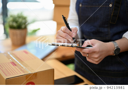 A female online shopping business owner checking her shipping orders. cropped 94213981
