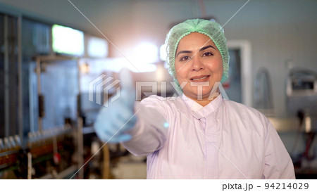 Happy Asian female portrait in manufacturing factory smiling - arm crossing and looking at the camera. Senior professional woman staff or worker in factory showing a thumb up and making arm crossed. Happy Asian female portrait in manufacturing factory smiling - arm crossing and looking at the camera. Senior professional woman staff or worker in factory showing a thumb up and making arm crossed. 94214029