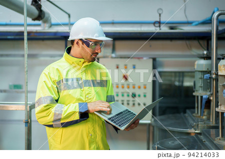 Senior professional quality control officer inspecting the manufacturing line and computer system in the beverage bottling factory. Industrial or machinery engineer inspecting and fixing the machines. 94214033