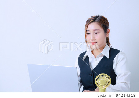 ハンディファンで涼みなが仕事をする女性 ハンディファンで涼みなが仕事をする女性 94214318