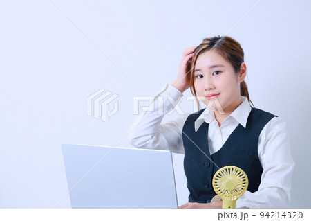 PC作業中に右手で頭を押さえる若いOL 94214320