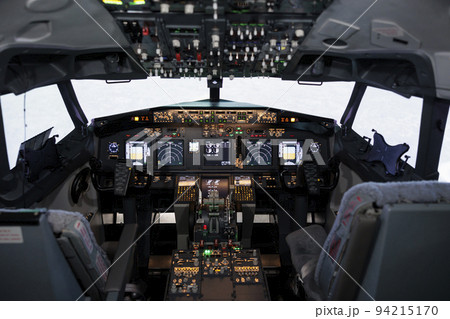 Empty airplane cockpit used by captain and copilot to fly, international airways jet with control panel buttons, steering wheel and dashboard command. Flying plane with engine throttle. 94215170