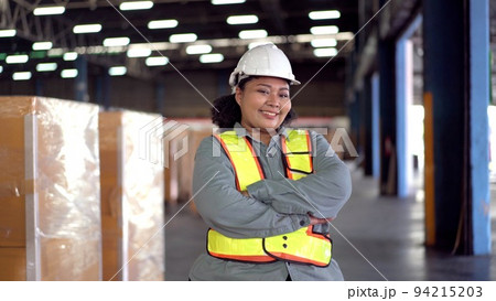 Happy - cheerful Asian woman engineer crossing arms and looking at camera. Female warehouse staff making arms crossed and looking at camera. Happy - cheerful Asian woman engineer crossing arms and looking at camera. Female warehouse staff making arms crossed and looking at camera. 94215203