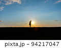 光の中で伸びをする女性 94217047