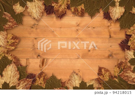 Autumn leaves on wood 94218015