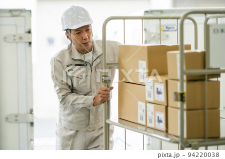 カゴ台車を押す倉庫管理者 94220038