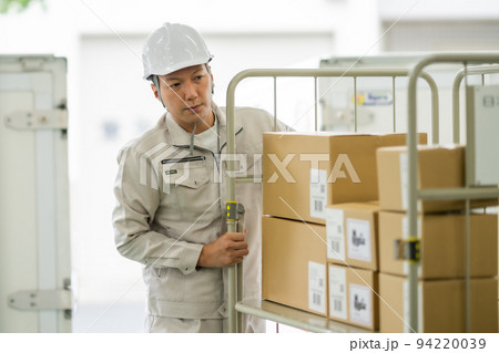 カゴ台車を押す倉庫管理者 94220039