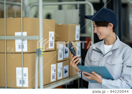 商品リストと現品を確認する女性スタッフ 94220044