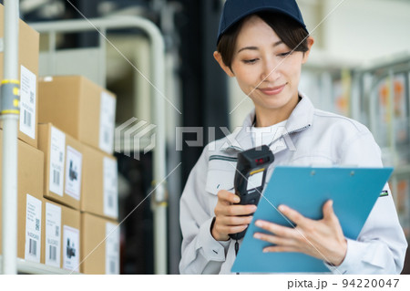 商品リストと現品を確認する女性スタッフ 94220047