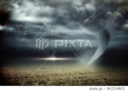 Stormy sky with tornado over field 94224803
