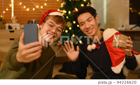 Happy friends using smartphone and take selfie in room decorated for celebrating New year and Christmas festive 94226620