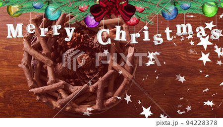 Image of merry christmas greetings text with stars over christmas decorations 94228378