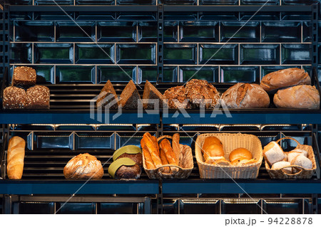 Freshly baked bread on a shelves in bakery, baguette and rolls. Different types of delicious loaves of bread in a german baker shop 94228878