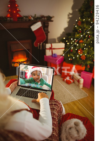 Santa claus making laptop christmas video call with smiling african american boy Santa claus making laptop christmas video call with smiling african american boy 94229436