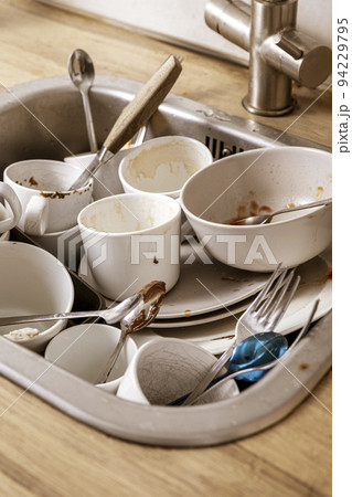Pile of unwashed, dirty dishes in the sink. Mess in the kitchen. Dirty kitchenware, plates and mugs. Chaos at home. Laziness. Cluttered apartment. Messy cutlery and dishware. Pile of unwashed, dirty dishes in the sink. Mess in the kitchen. Dirty kitchenware, plates and mugs. Chaos at home. Laziness. Cluttered apartment. Messy cutlery and dishware. 94229795