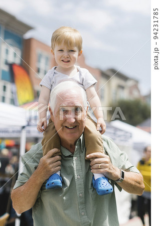 Portrait of grandfather carrying grandson (2-3) on shoulders Portrait of grandfather carrying grandson (2-3) on shoulders 94231785