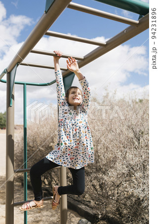 Girl (2-3) on monkey bars 94231896