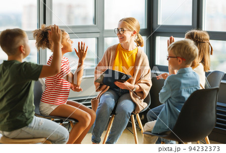 schoolchildren raise their hand looking at teacher to answer in class during psychological training schoolchildren raise their hand looking at teacher to answer in class during psychological training 94232373