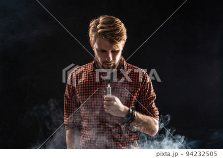 A young man with a beard and a stylish hairstyle in a shirt, smoking a cigarette, a viper, a room, a studio, smoke, enjoyment A young man with a beard and a stylish hairstyle in a shirt, smoking a cigarette, a viper, a room, a studio, smoke, enjoyment 94232505