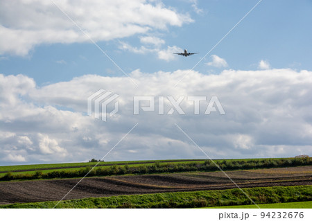 緑の畑作地帯を飛ぶジェット旅客機 緑の畑作地帯を飛ぶジェット旅客機 94232676