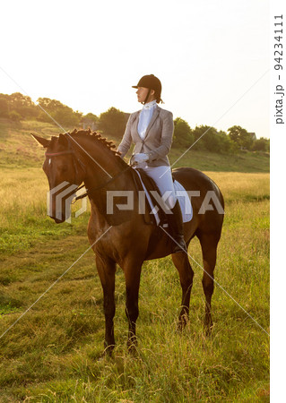 Equestrian sport. Young woman riding horse on dressage advanced test 94234111