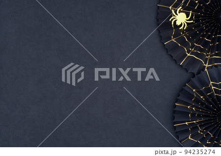 Halloween background. The scary Halloween paper fans with gold cobwebs on a dark textured background. 94235274