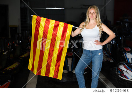 Lucky woman with race flag standing near car 94236468
