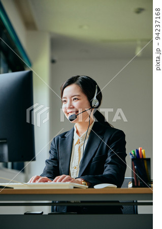 オフィスで電話対応する若いオペレーター オフィスで電話対応する若いオペレーター 94237168