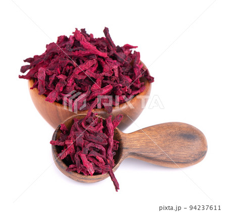 Dry beetroot in wooden bowl and spoon, isolated on the white background. Chopped dried beet. 94237611