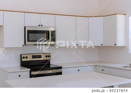 New kitchen appliances and kitchen cabinets are being installed in a newly constructed house New kitchen appliances and kitchen cabinets are being installed in a newly constructed house 94237834