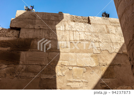 Different hieroglyphs on the walls and columns in the Karnak temple. Karnak temple is the largest complex in ancient Egypt. 94237873