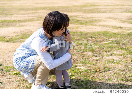 公園の芝生広場で遊ぶ園児と保育士 公園の芝生広場で遊ぶ園児と保育士 94240050