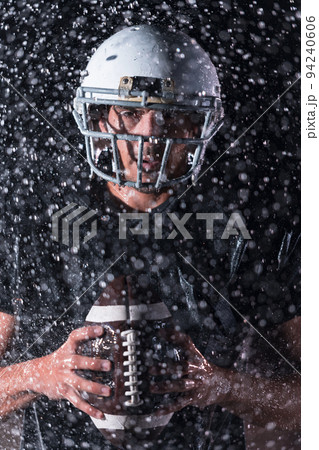 American Football Field: Lonely Athlete Warrior Standing on a Field Holds his Helmet and Ready to Play. Player Preparing to Run, Attack and Score Touchdown. Rainy Night with Dramatic Fog, Blue Light American Football Field: Lonely Athlete Warrior Standing on a Field Holds his Helmet and Ready to Play. Player Preparing to Run, Attack and Score Touchdown. Rainy Night with Dramatic Fog, Blue Light 94240606