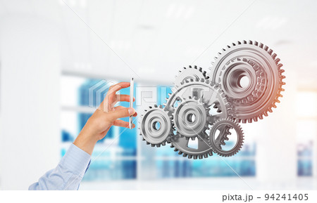 Engine mechanism in male hands as symbol for cooperation or teamworking. Mixed media Engine mechanism in male hands as symbol for cooperation or teamworking. Mixed media 94241405