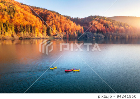 Aerial view of people on boats on blue lake in mountains Aerial view of people on boats on blue lake in mountains 94241950