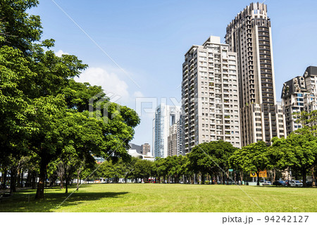 Low angle view of park green space and modern buildings on both sides in downtown Taichung, Taiwan. here is near the National Taichung Theater. Low angle view of park green space and modern buildings on both sides in downtown Taichung, Taiwan. here is near the National Taichung Theater. 94242127