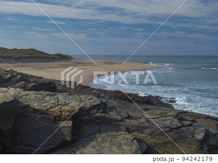 View of empty Praia do Sissal sand beach with ocean waves and sharp rock and cllifs at wild Rota Vicentina coast near Porto Covo, Portugal. View of empty Praia do Sissal sand beach with ocean waves and sharp rock and cllifs at wild Rota Vicentina coast near Porto Covo, Portugal. 94242179