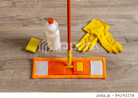 Flat mop and rubber gloves on the floor. 94243256
