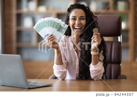 Emotional middle eastern woman showing cash and bitcoin Emotional middle eastern woman showing cash and bitcoin 94244307