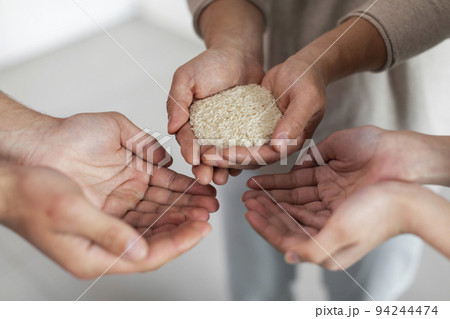 Unrecognizable man holding rice in his hands, sharing with family Unrecognizable man holding rice in his hands, sharing with family 94244474
