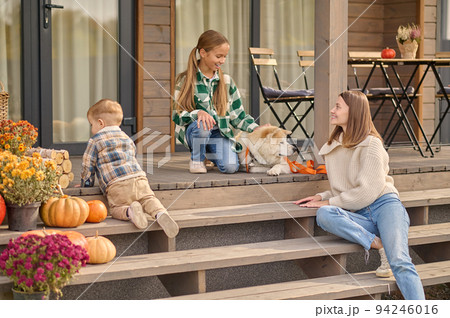 Female parent spending time with her kids on the veranda 94246016