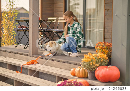 Cheerful young lady enjoying the company of her dog Cheerful young lady enjoying the company of her dog 94246023
