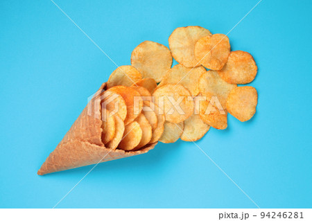 Waffle Cone with Potato Chips on blue background. Fast Food concept Waffle Cone with Potato Chips on blue background. Fast Food concept 94246281