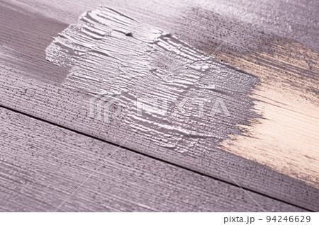 painting a wooden surface with a brush and gray.  paint. Natural wooden texture. Renovation or repair construction. 94246629