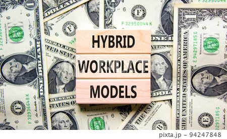 Hybrid workplace models symbol. Concept words Hybrid workplace models on wooden blocks on dollar bills. Beautiful background from dollar bills. Business hybrid workplace models concept. Copy space Hybrid workplace models symbol. Concept words Hybrid workplace models on wooden blocks on dollar bills. Beautiful background from dollar bills. Business hybrid workplace models concept. Copy space 94247848
