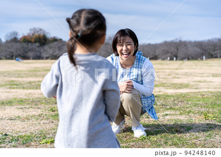 公園の芝生広場で遊ぶ園児と保育士 公園の芝生広場で遊ぶ園児と保育士 94248140