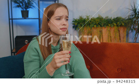 Sad depressed young girl girl suffers from unrequited love, drinking champagne, problem, bad news 94248315