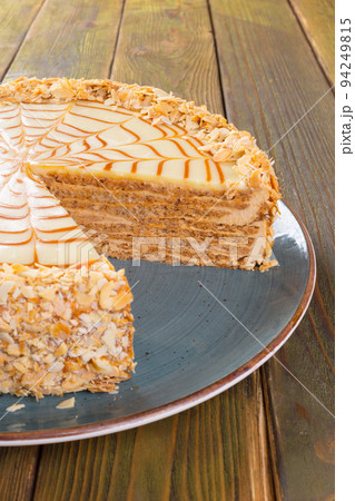 Cut caramel cake on plate on wooden table Cut caramel cake on plate on wooden table 94249815