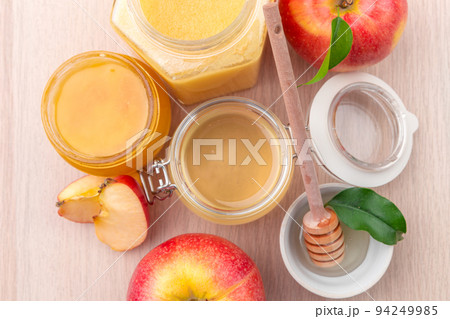 Jewish holiday Rosh Hashanah background with honey and apples on wooden table. 94249985